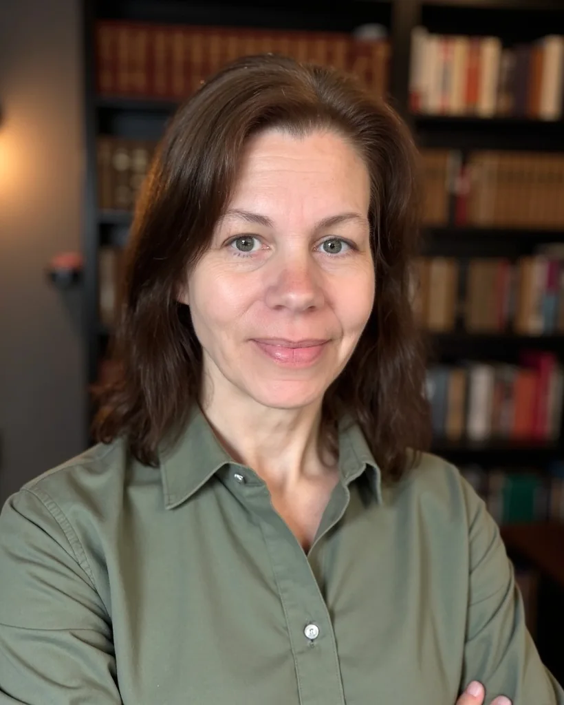 Erica R. Buteau in a professional portrait before bookshelves