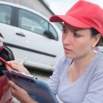 Woman looking at car and thinking about how to save money on car repair.