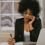 woman in black blazer holding smartphone