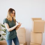 glad woman writing down notes during while packing