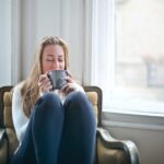 woman holding gray ceramic mug