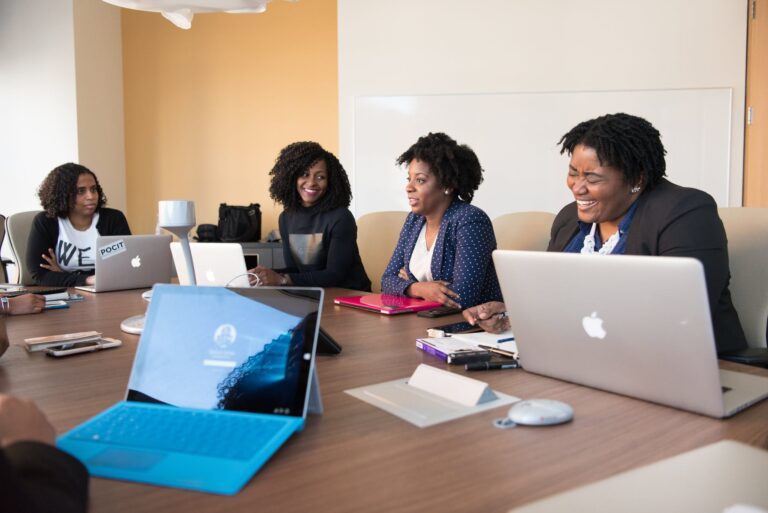 group of people talking to each other in front of brown wooden table