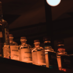 A liquor collection in low orange light.