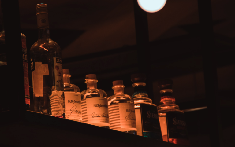 A liquor collection in low orange light.