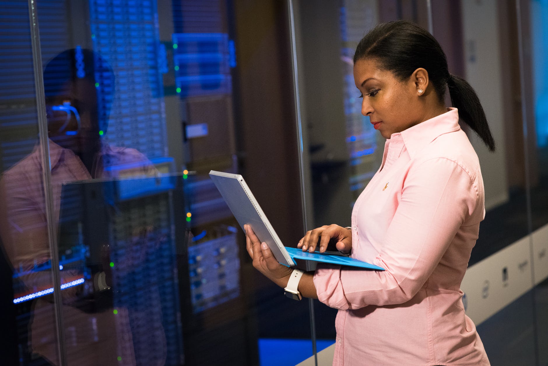 photo of woman holding a gray laptop in front of systems