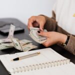 crop payroll clerk counting money while sitting at table