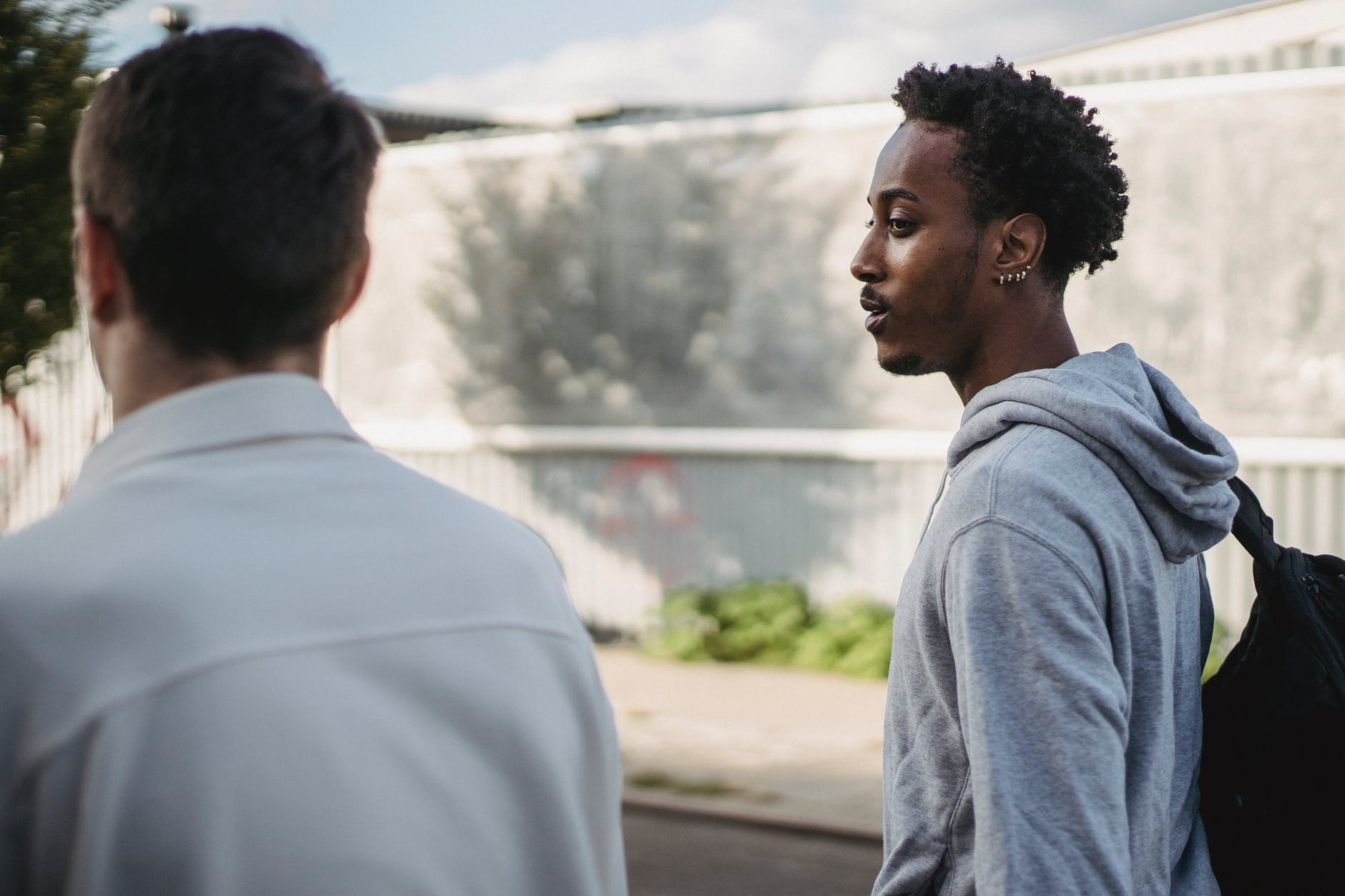 trendy young multiracial guys strolling on street in city