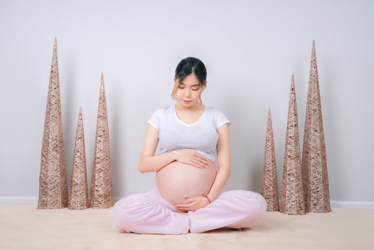 woman showing her baby bump while sitting on floor