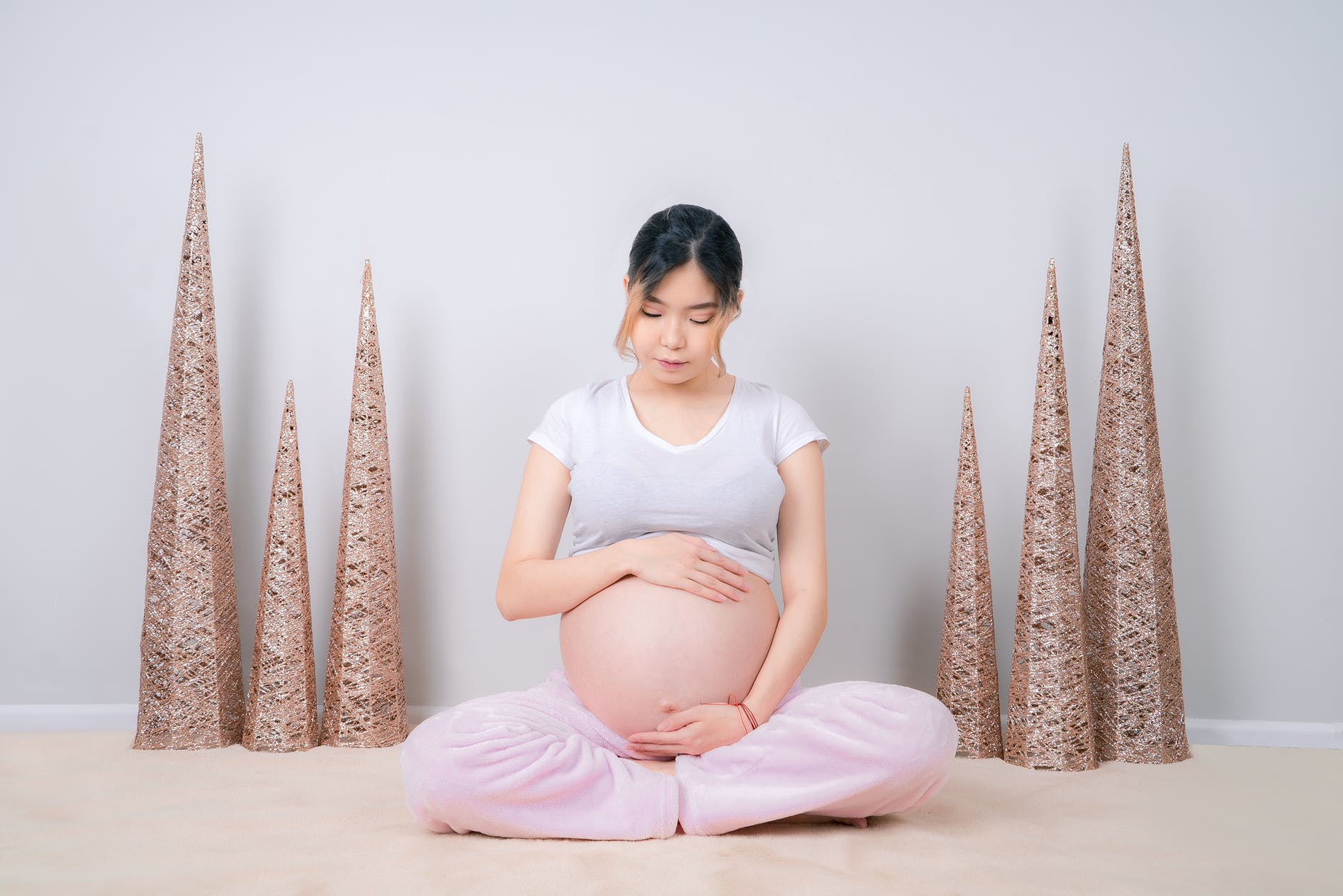 woman showing her baby bump while sitting on floor