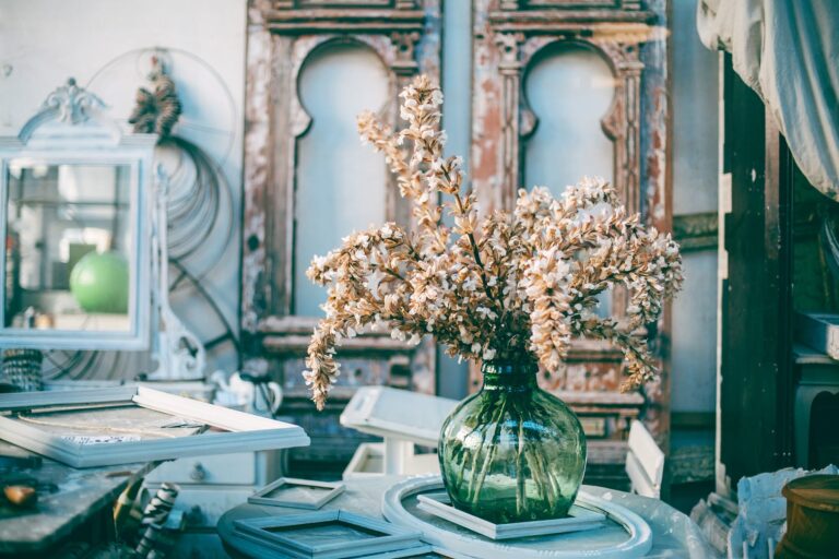 vase with gentle flowers placed on table in art salon