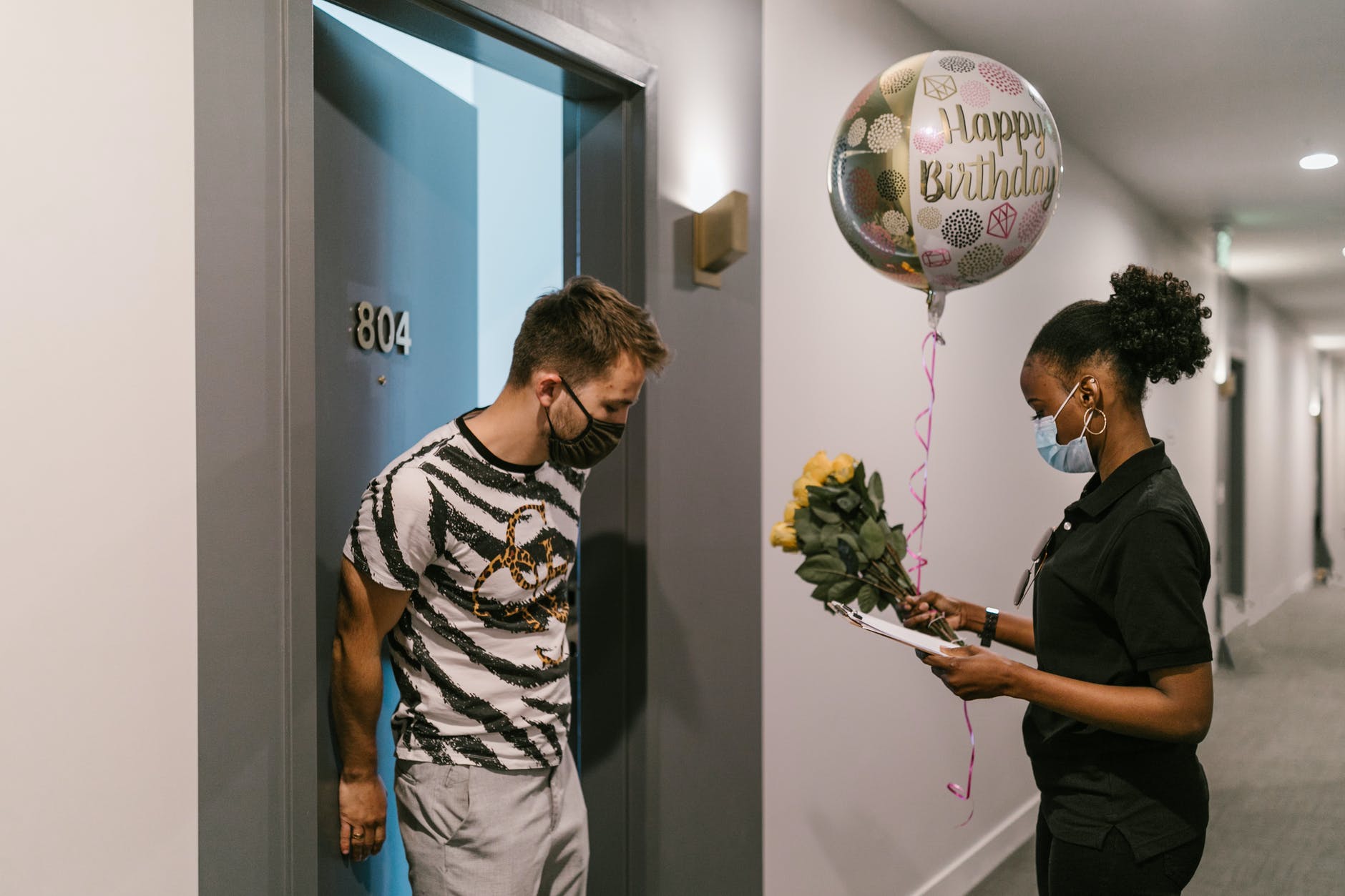 a deliverywoman delivering a balloon and a bouquet of flowers