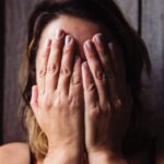 woman covering her face with her hands