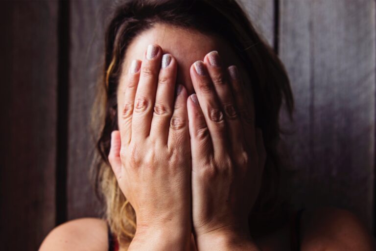 woman covering her face with her hands