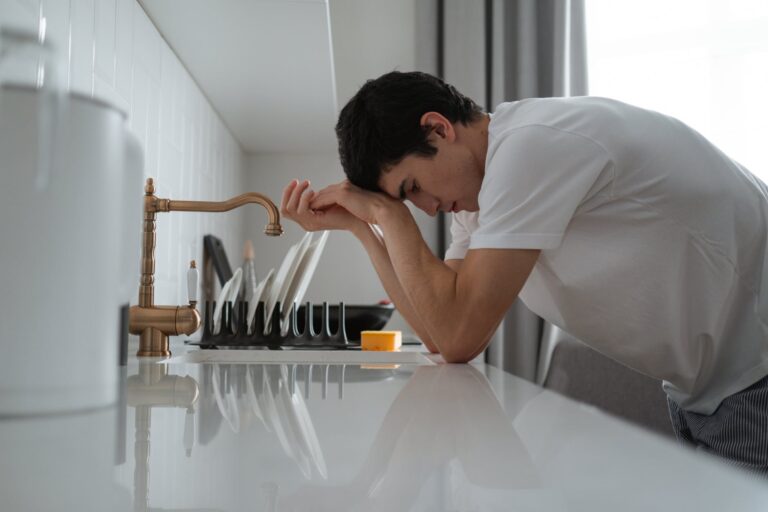 man leaning on the kitchen counter