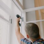 anonymous man installing window in room