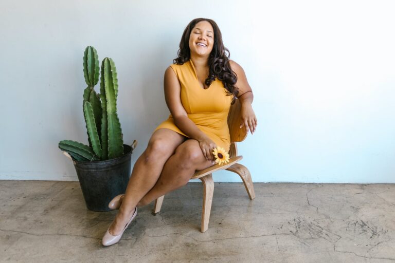 woman in yellow tank top sitting on brown wooden chair