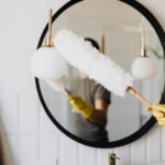 crop woman dusting lamp during housework