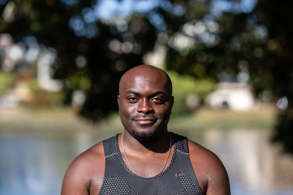 a bald man wearing a black tank top smiling