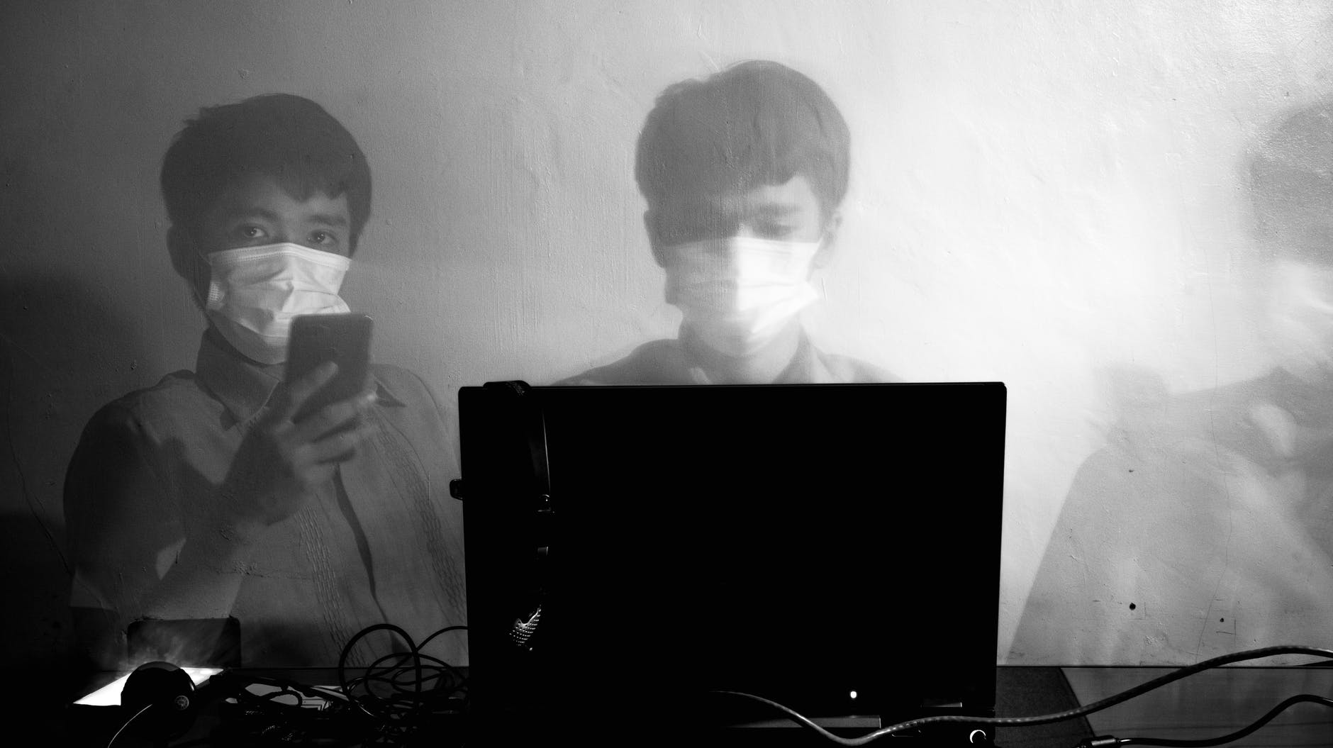 male worker using laptop and phone during coronavirus pandemic