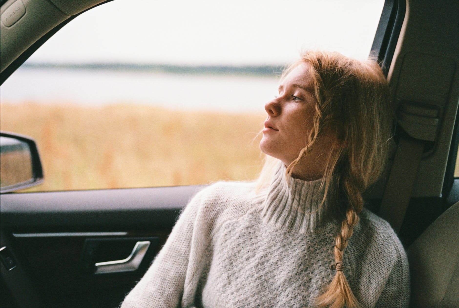 woman in sweater sitting inside a car