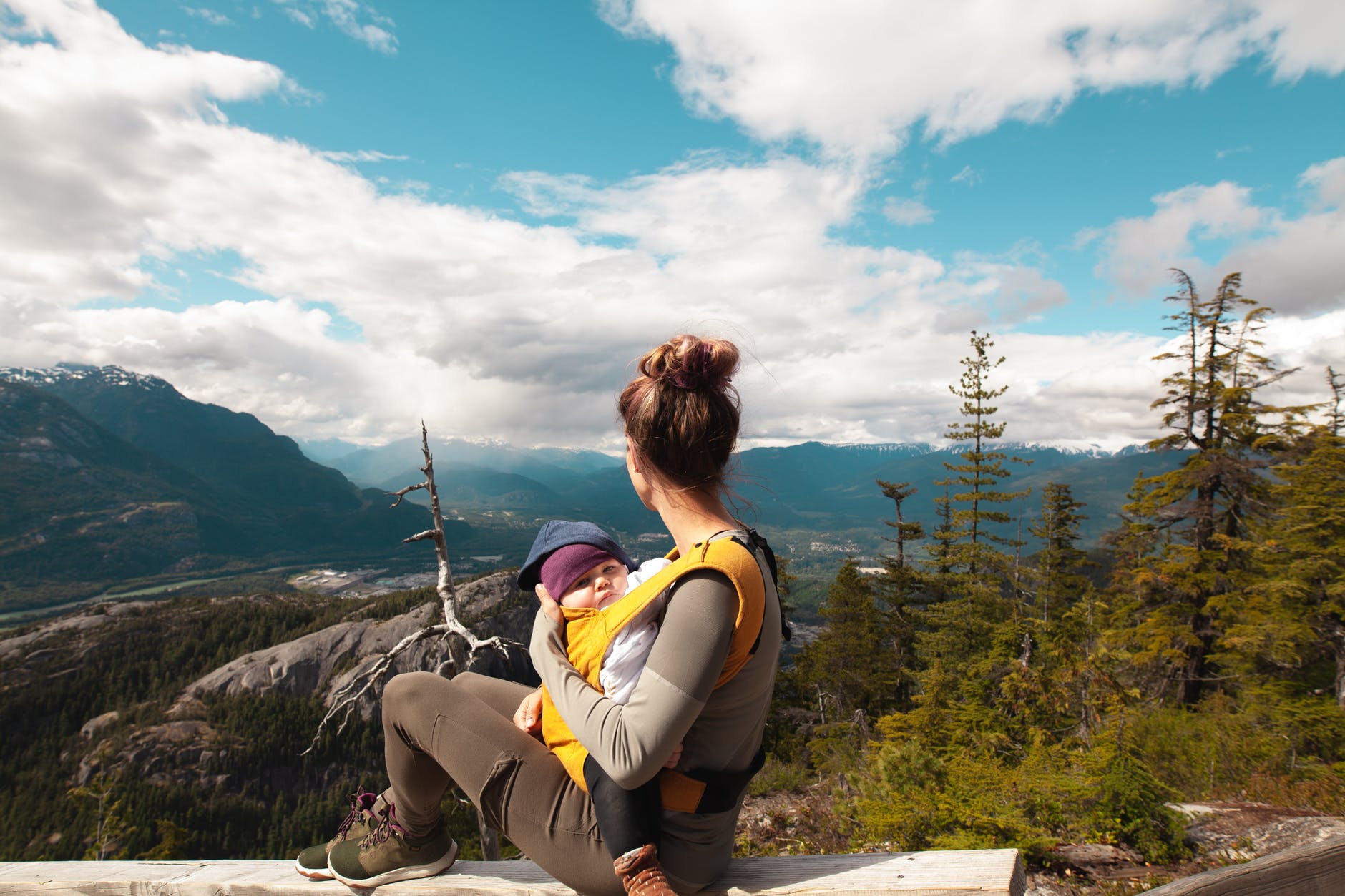 mother carrying her baby while looking at the nature scenery