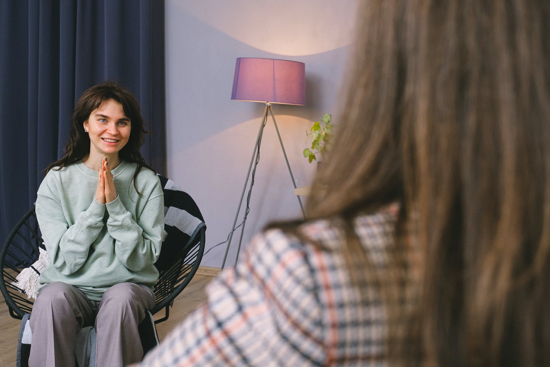 happy young woman smiling while talking to psychologist in modern office