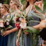 selective focus photography of women holding wedding flowers
