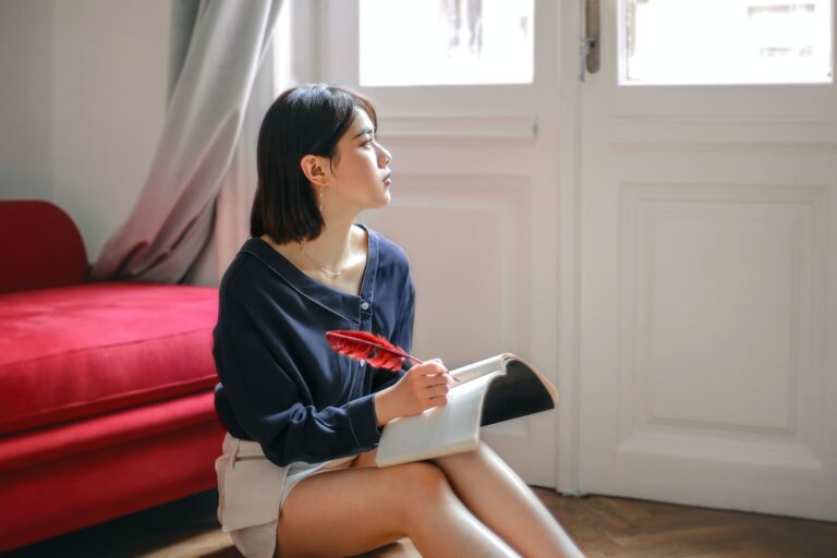 thoughtful woman writing in notebook at home