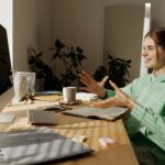 woman in green and white stripe shirt sitting at table