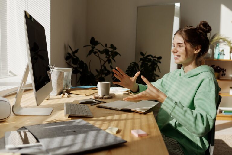 woman in green and white stripe shirt sitting at table