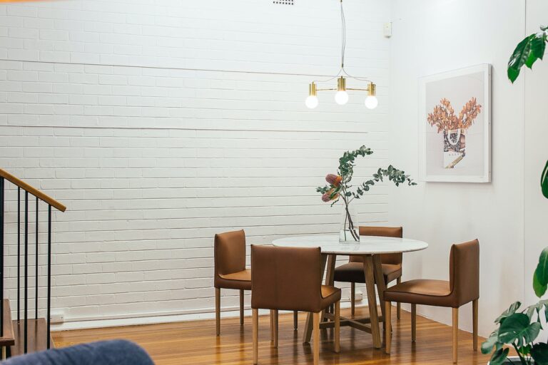 table with vase near chairs and painting