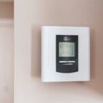 white thermostat hanging on the wall