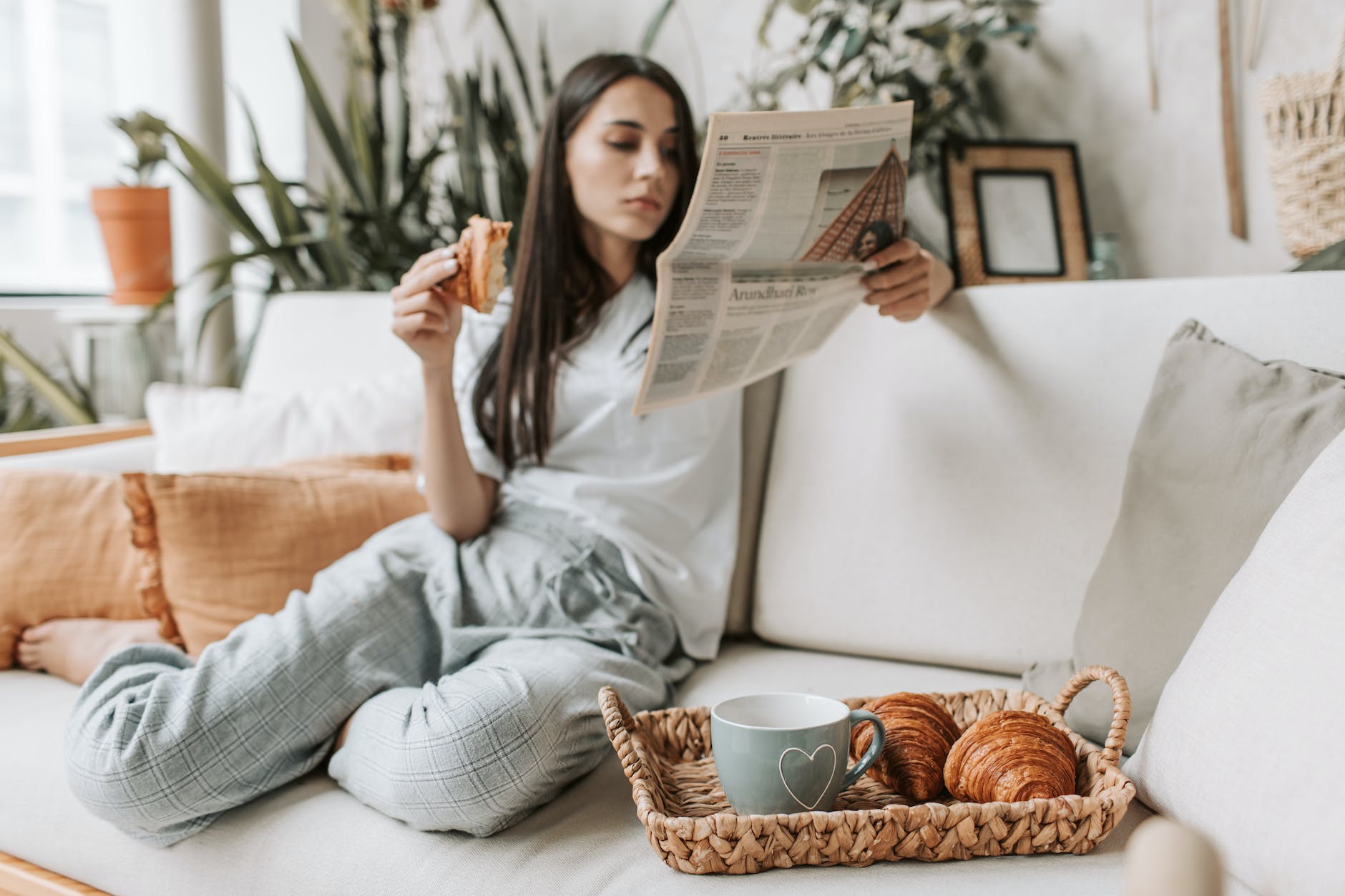 a woman reading a newspaper while having breakfast