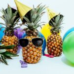 photo of three pineapples surrounded by balloons