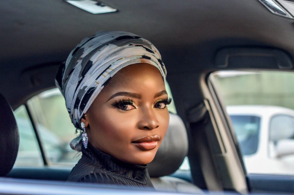 photo of woman wearing white and black floral headscarf inside car