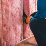 A worker inspecting insulation in a building