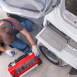 Man attempting to repair a washing machine