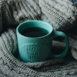A mug with a warm drink on a blanket