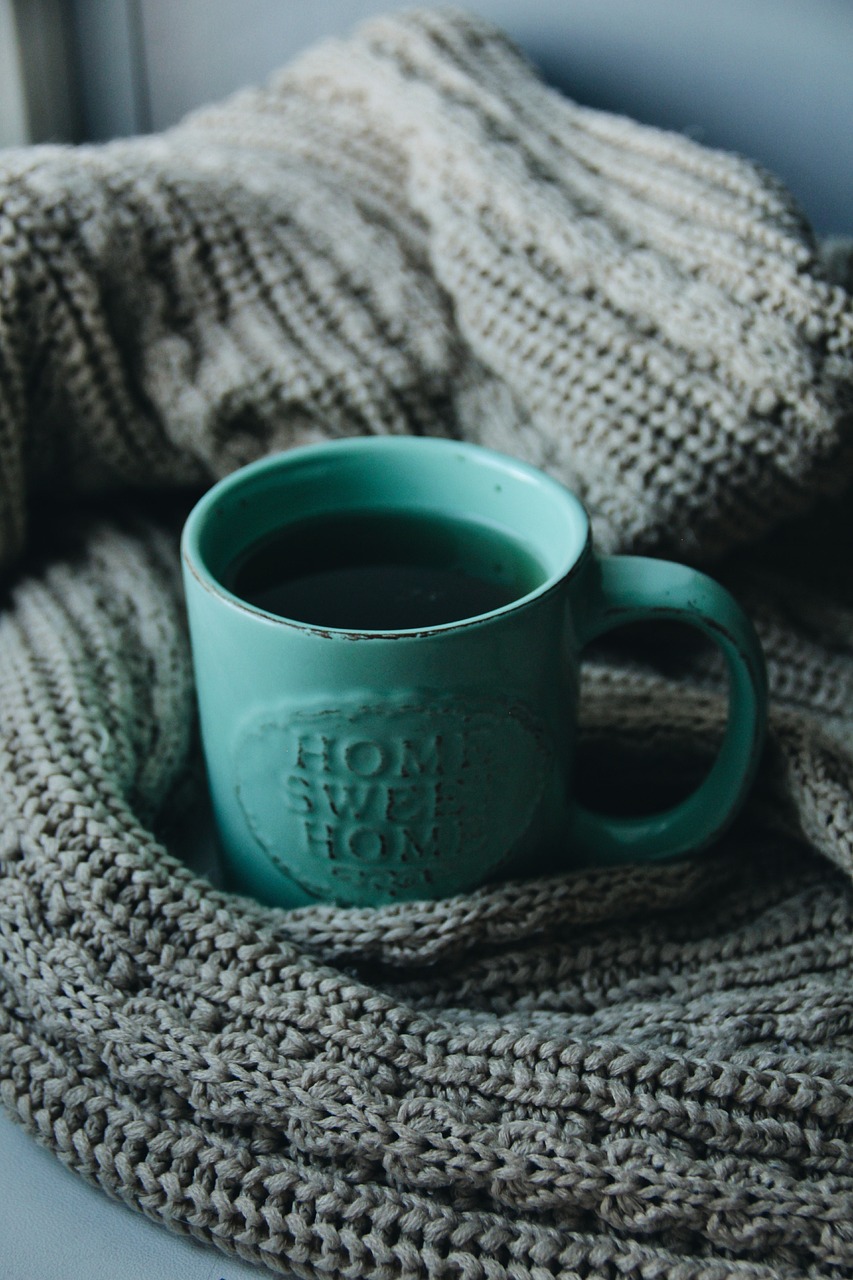 A mug with a warm drink on a blanket