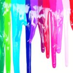 Many colors of paint running down a white background