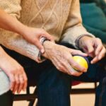 A person helping a senior at an assisted living facility