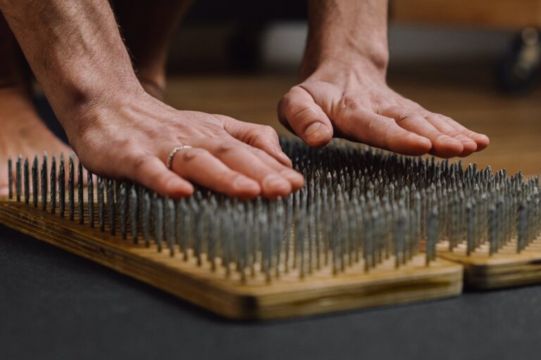 a person leaning on bed of nails