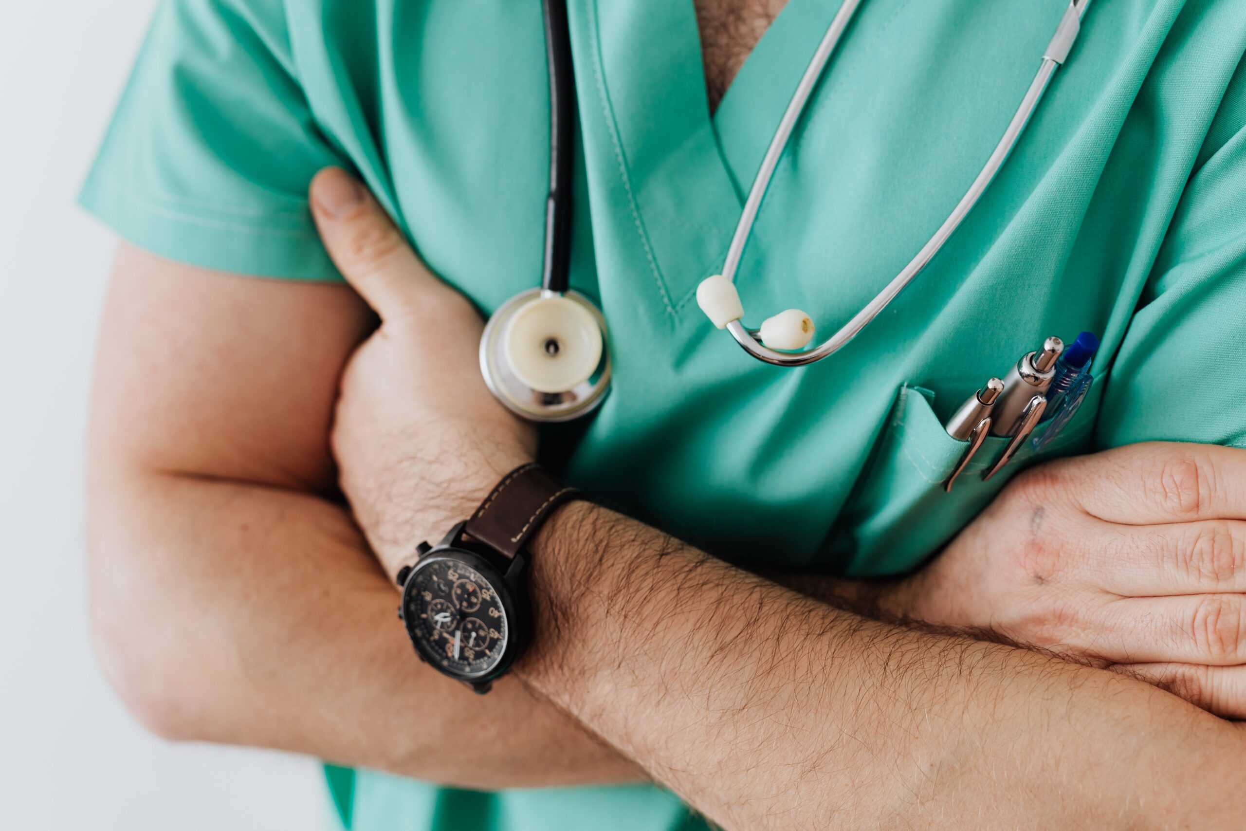 Close-up shot of a doctor standing with their arms crossed.