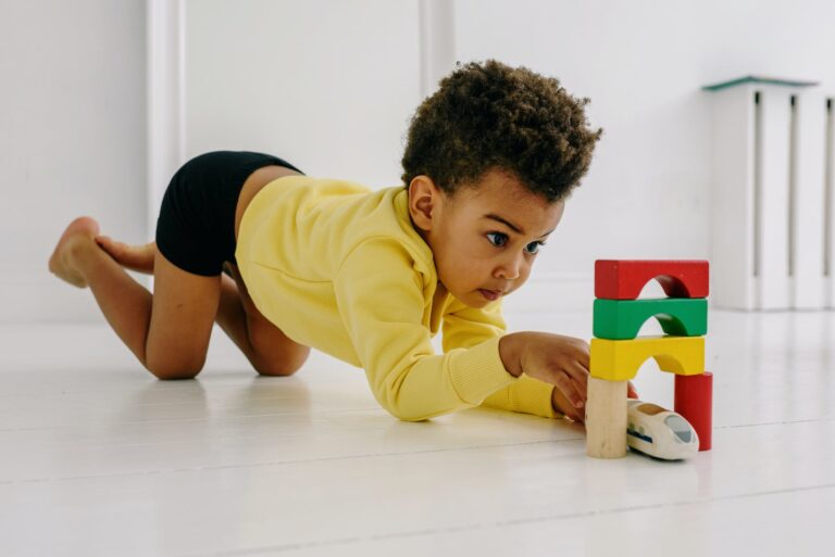 a boy in yellow sweater playing on the floor