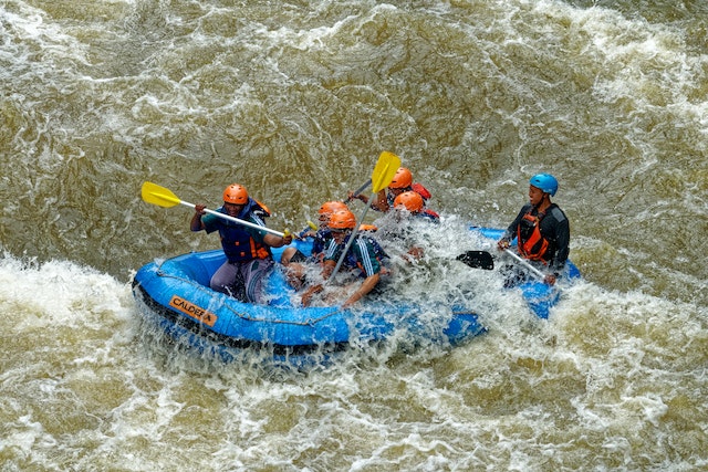 A group of people on a raft as a wave is incoming