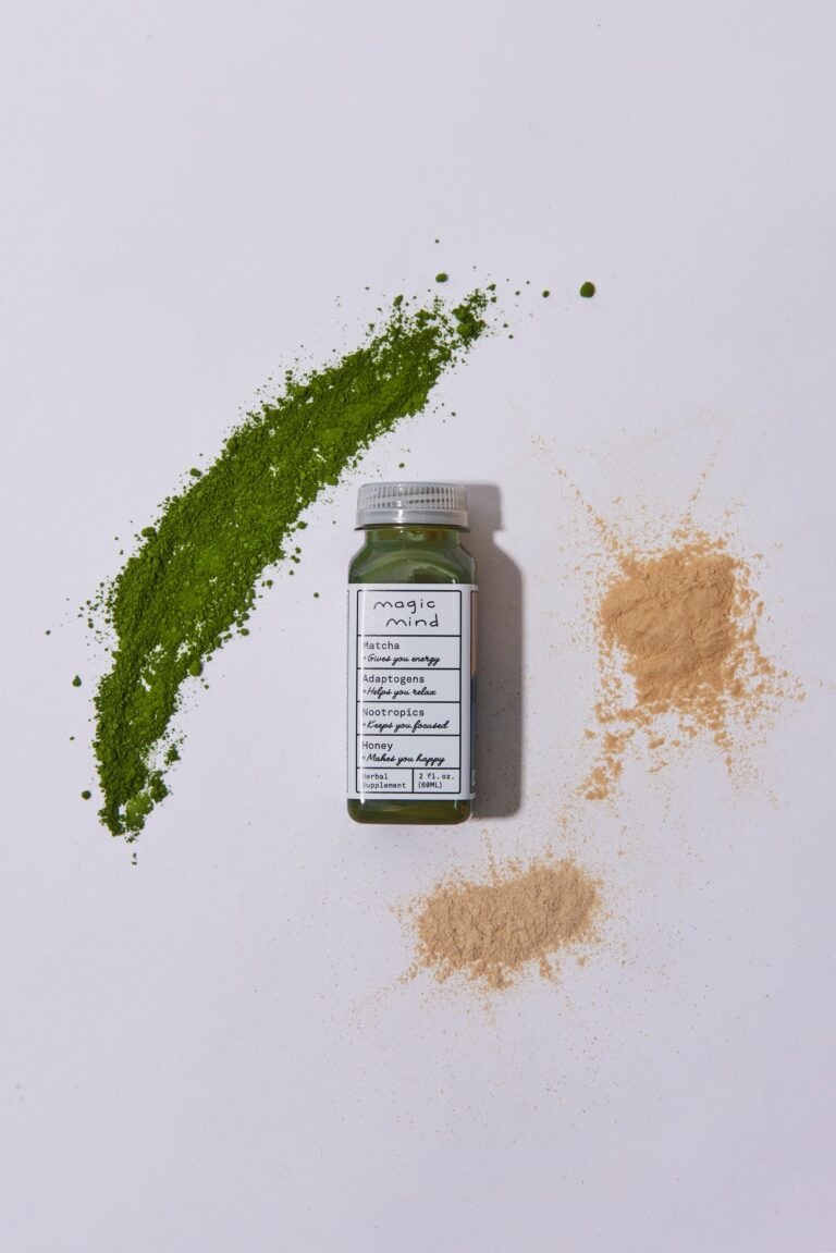 A bottle of a green powder, with two brown powders in small piles next to it, and a streak of green powder above and to the right