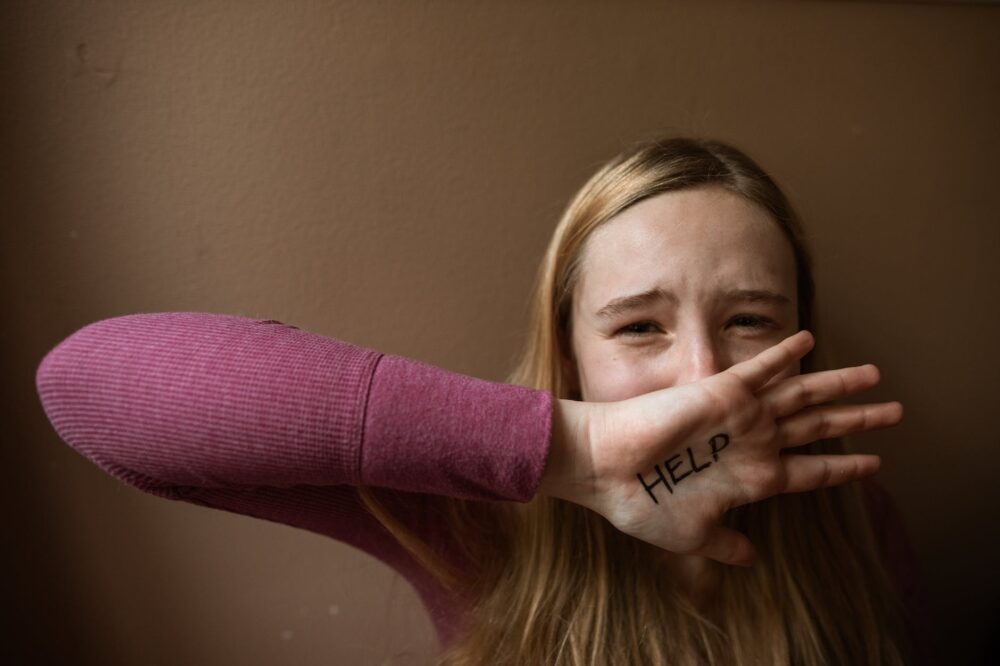 a word help written on the woman s palm