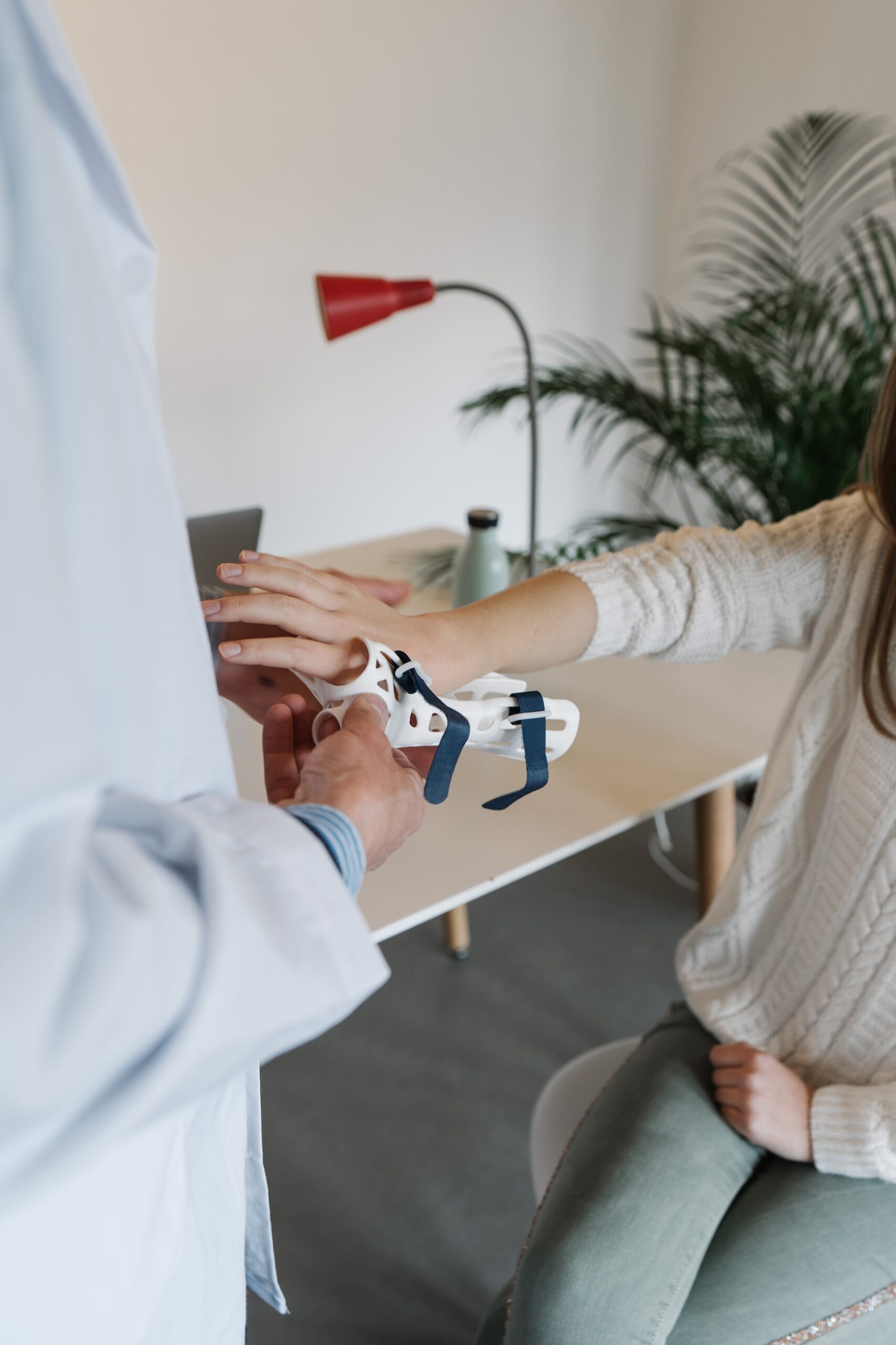 A medical professional placing a wrist brace on a young woman