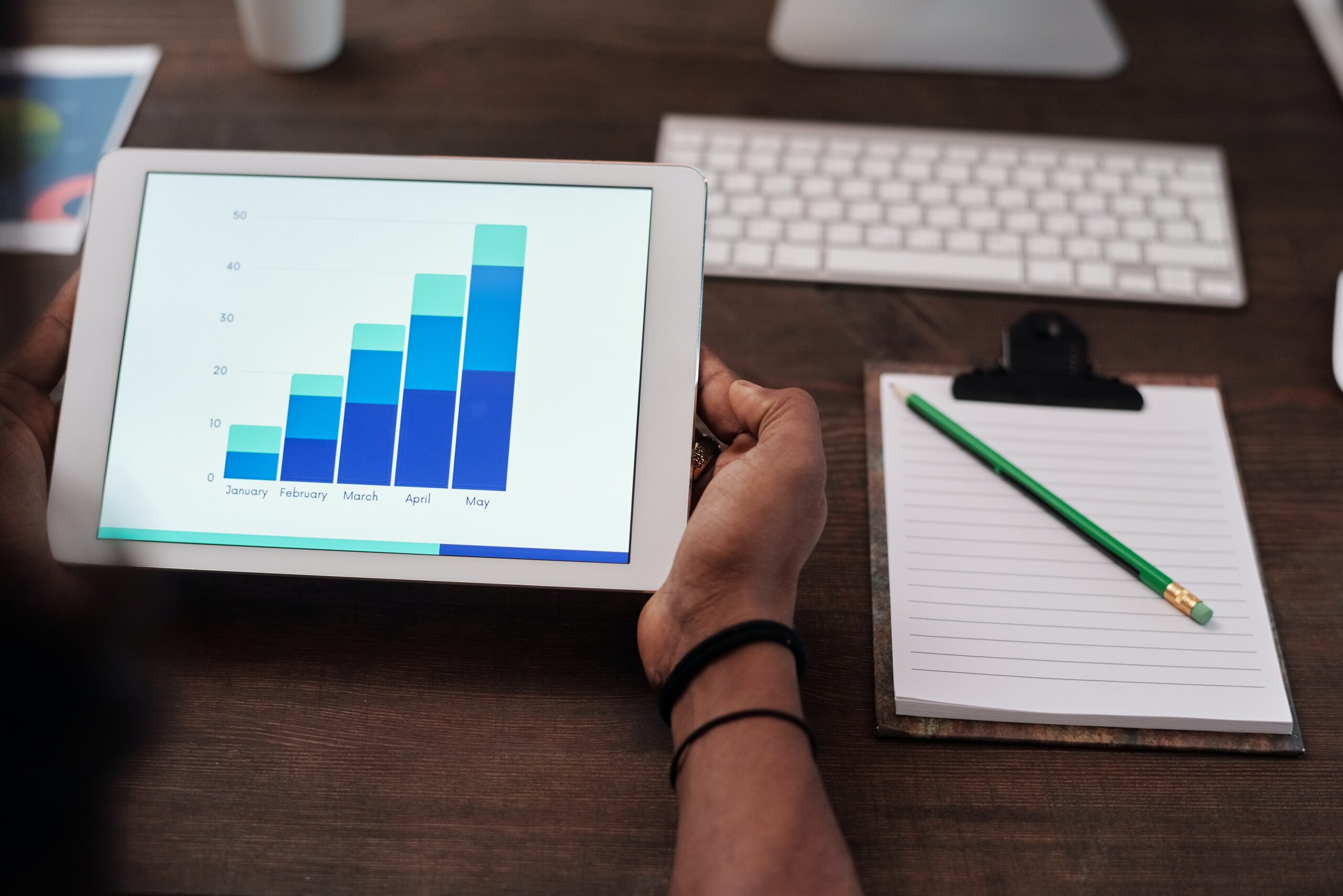 Person holding a tablet that shows statistics.