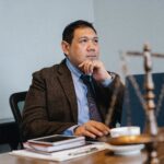 Man sitting in suit sitting at desk.